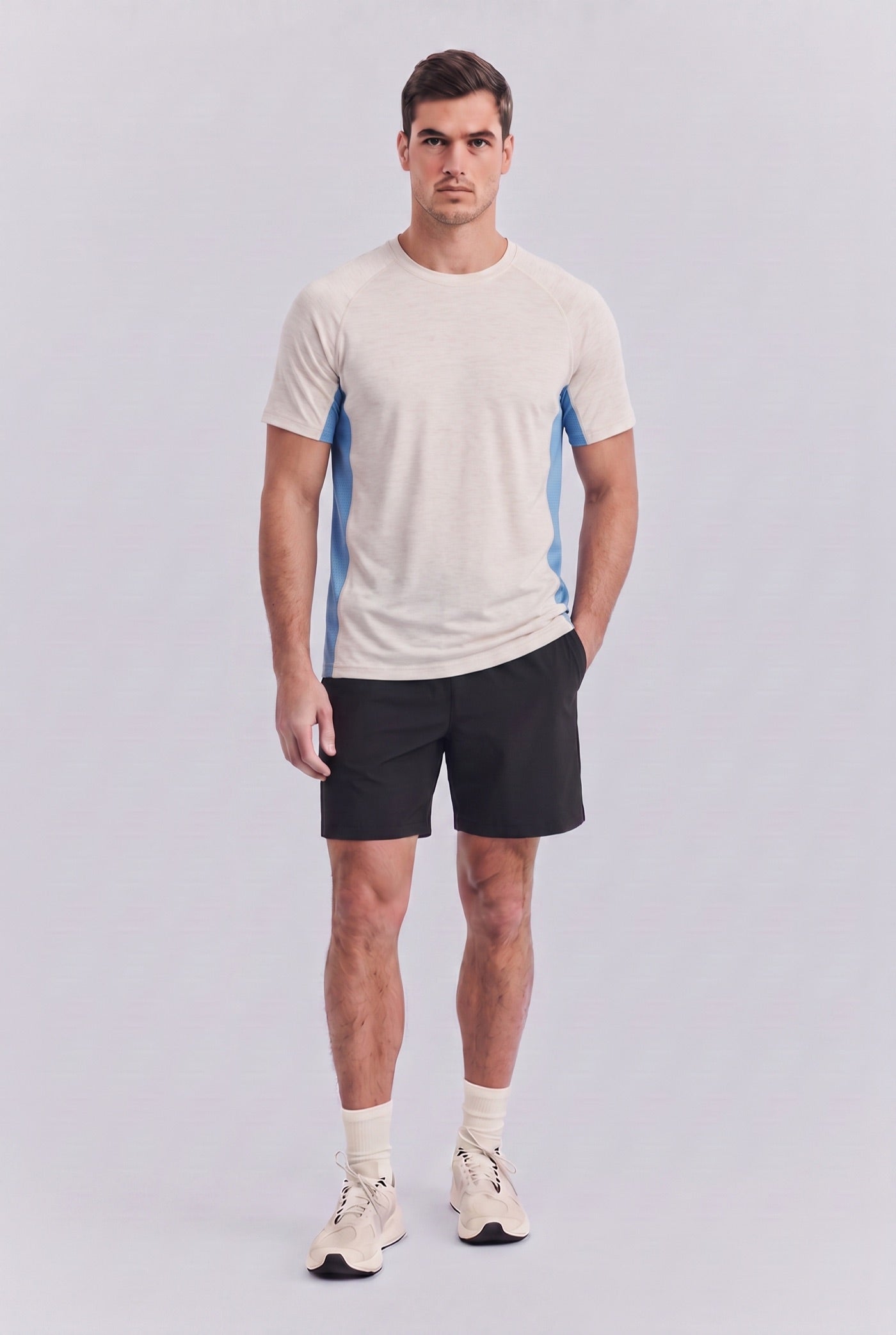 The merino tee worn with training shorts, standing, studio light
