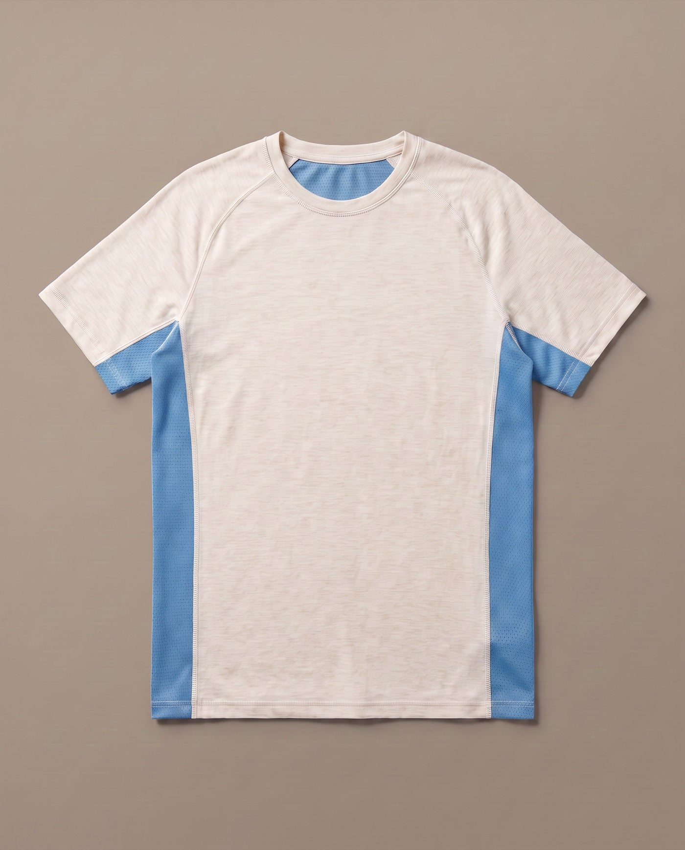 The PRFORM merino tee laid flat: oatmeal merino body with blue merino mesh side panels
